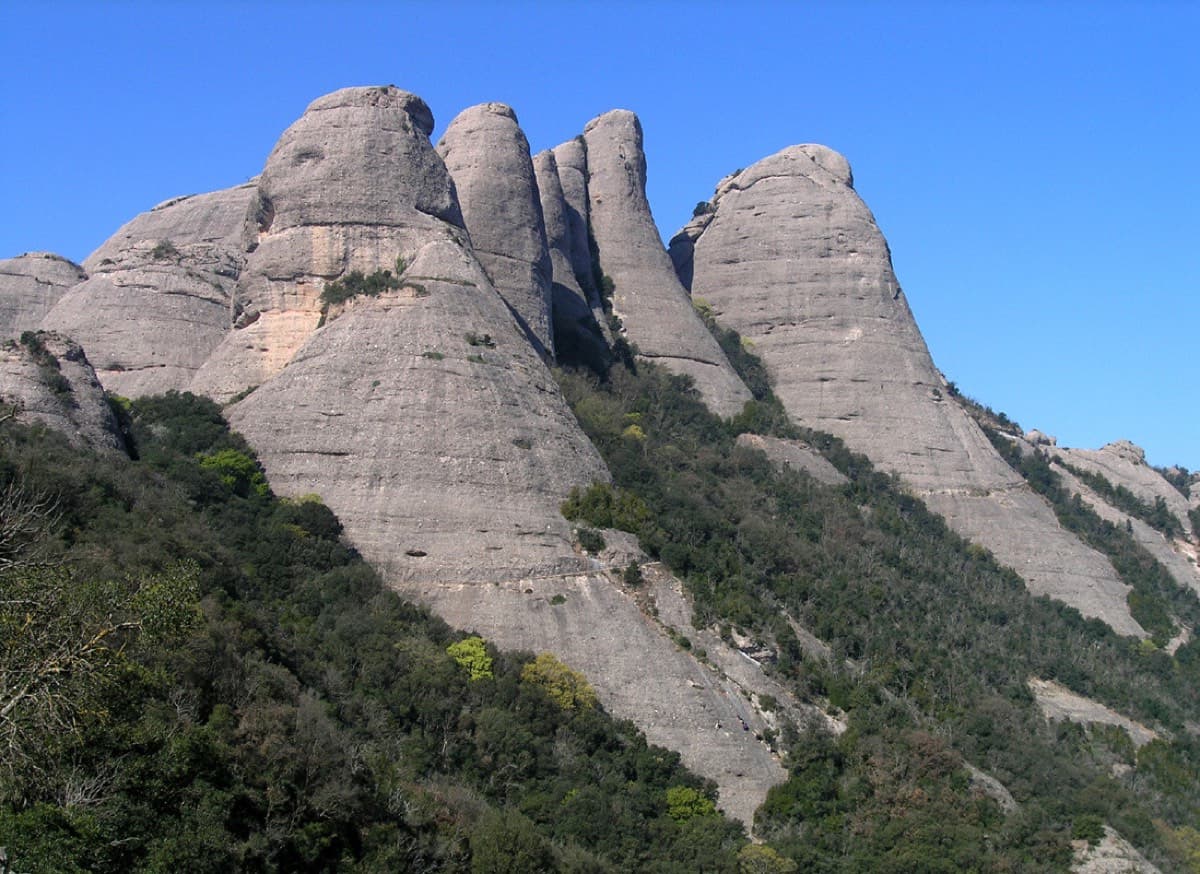 The Gorros group, titled by the photographer from left to right: Gorra Marinera (the big dome on the left), the slender Magdalenes towers, the Gorra Frígia (the big cone on the right) and Trencabarrals. 98 Octanos is on the north face of the Magdalena Superior, between the Magdalenes and the Frígia.