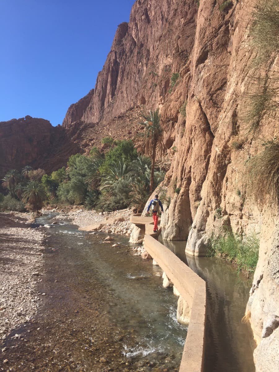Walking along the wall of the irrigation channel at the foot of the cliff, the dry-foot way to the Mansour sector from inside the gorge.