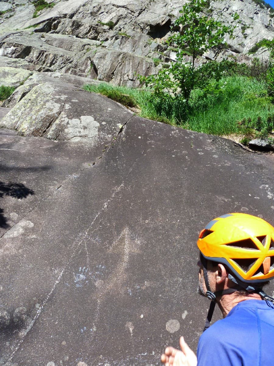 The start of the route: a dark slab with a large arrow carved into the rock, where the path arrives.