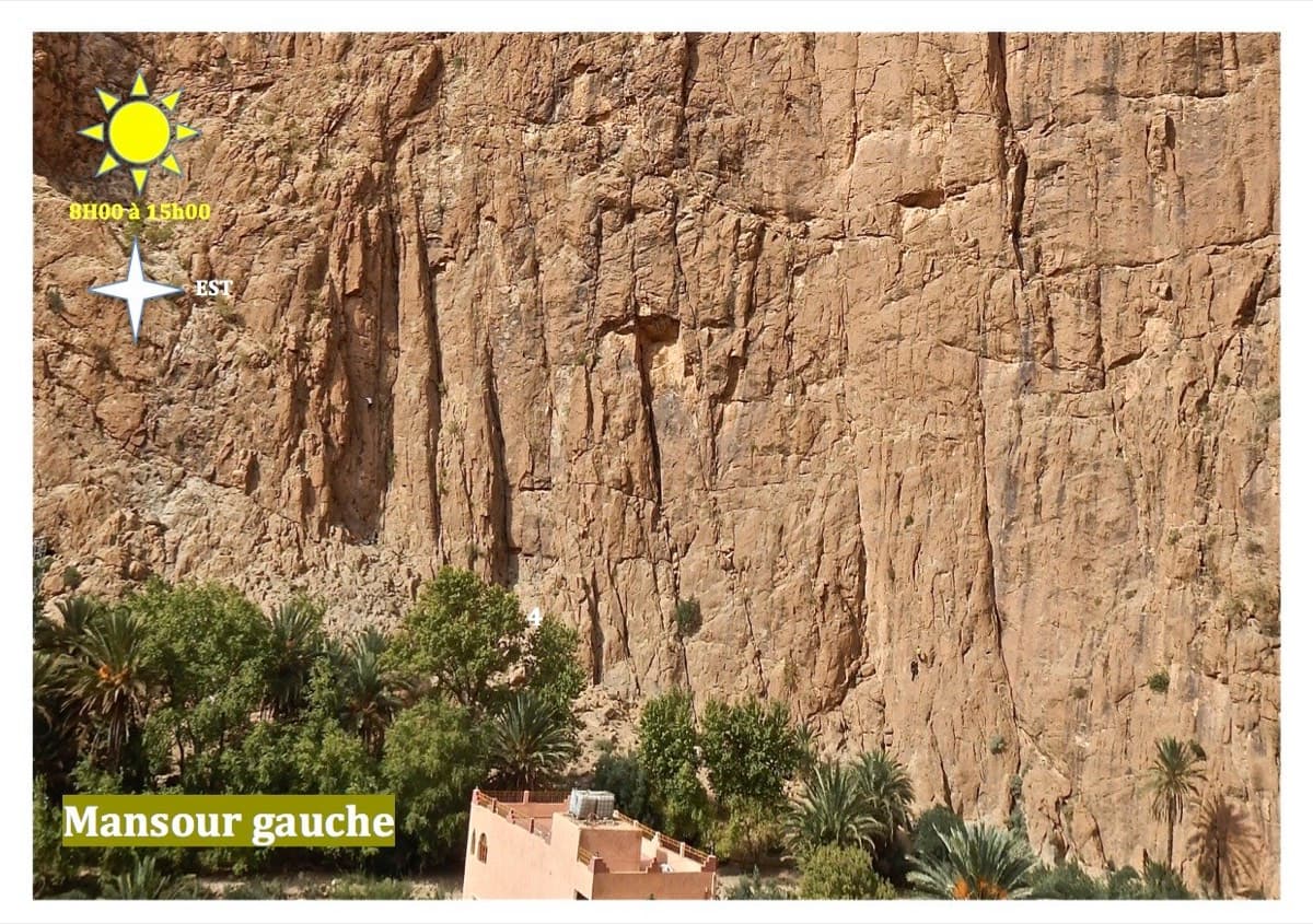 The Mansour Gauche wall above the palm grove and the guesthouses at the gorge entrance (labelled sector photo; the wall faces east and is in the sun from about 8:00 to 15:00). Cœur de Palmier starts left of the big gully and chimney that splits the face.