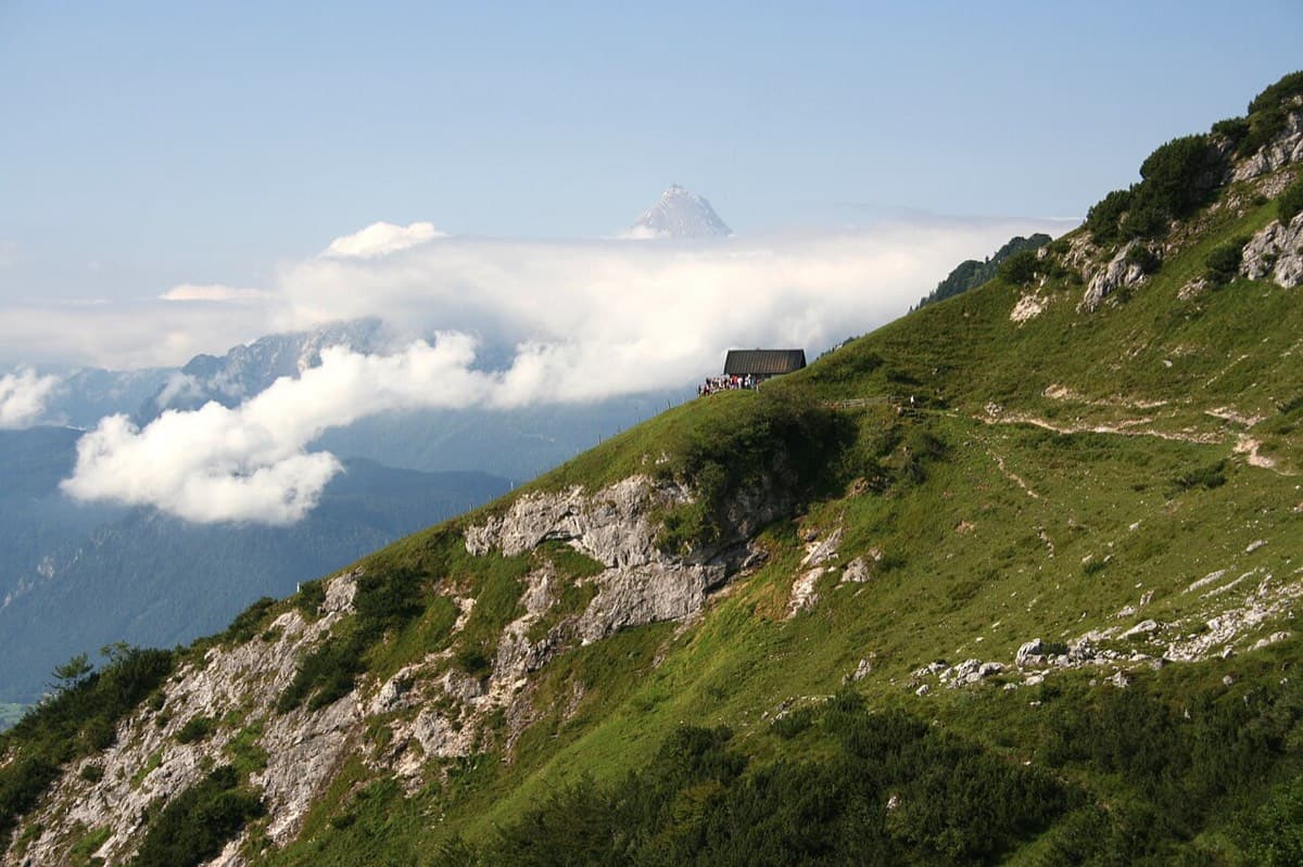 The Scheibenkaser hut on its grassy shoulder, reached after about 1 h 15 on path 466; the route to the wall leaves from here.
