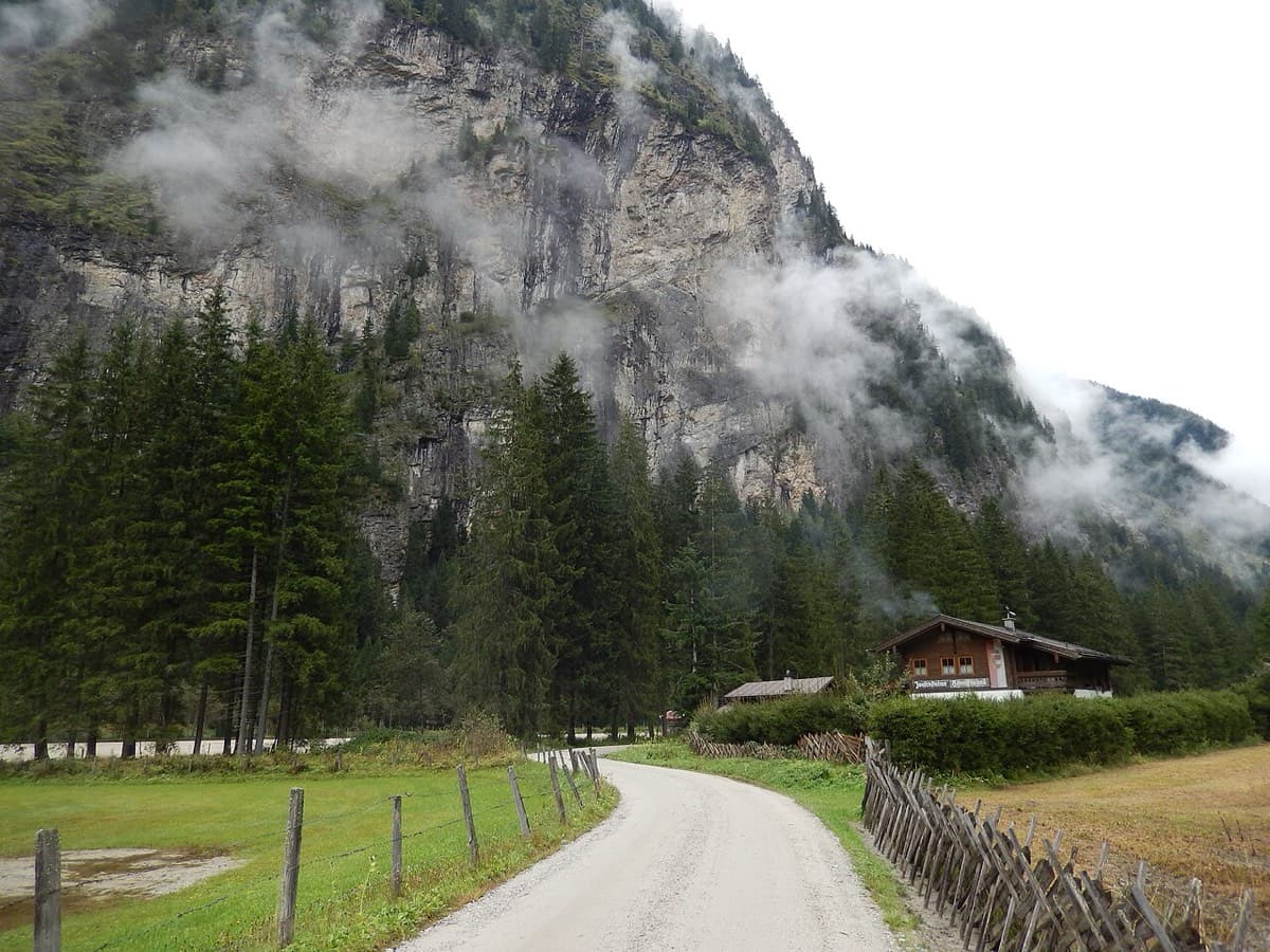 The forest road up the Kötschachtal where it reaches the Himmelwandhütte snack bar (the chalet on the right), with the Himmelwand above. The approach passes the hut and carries straight on up the valley.