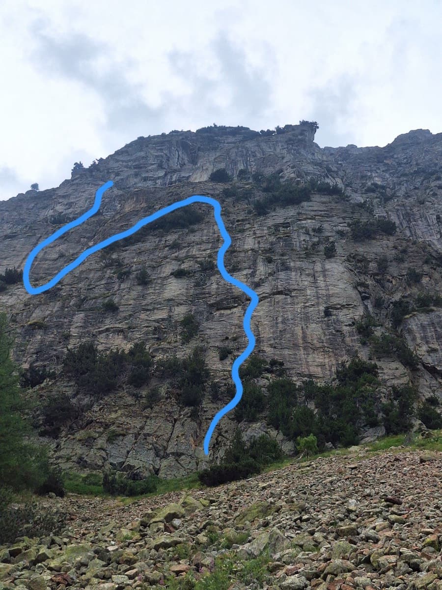The wall seen from the scree on the approach. The blue line is the neighbouring route Lockdown, which starts about 100 m left of Il Gatto e la Volpe.