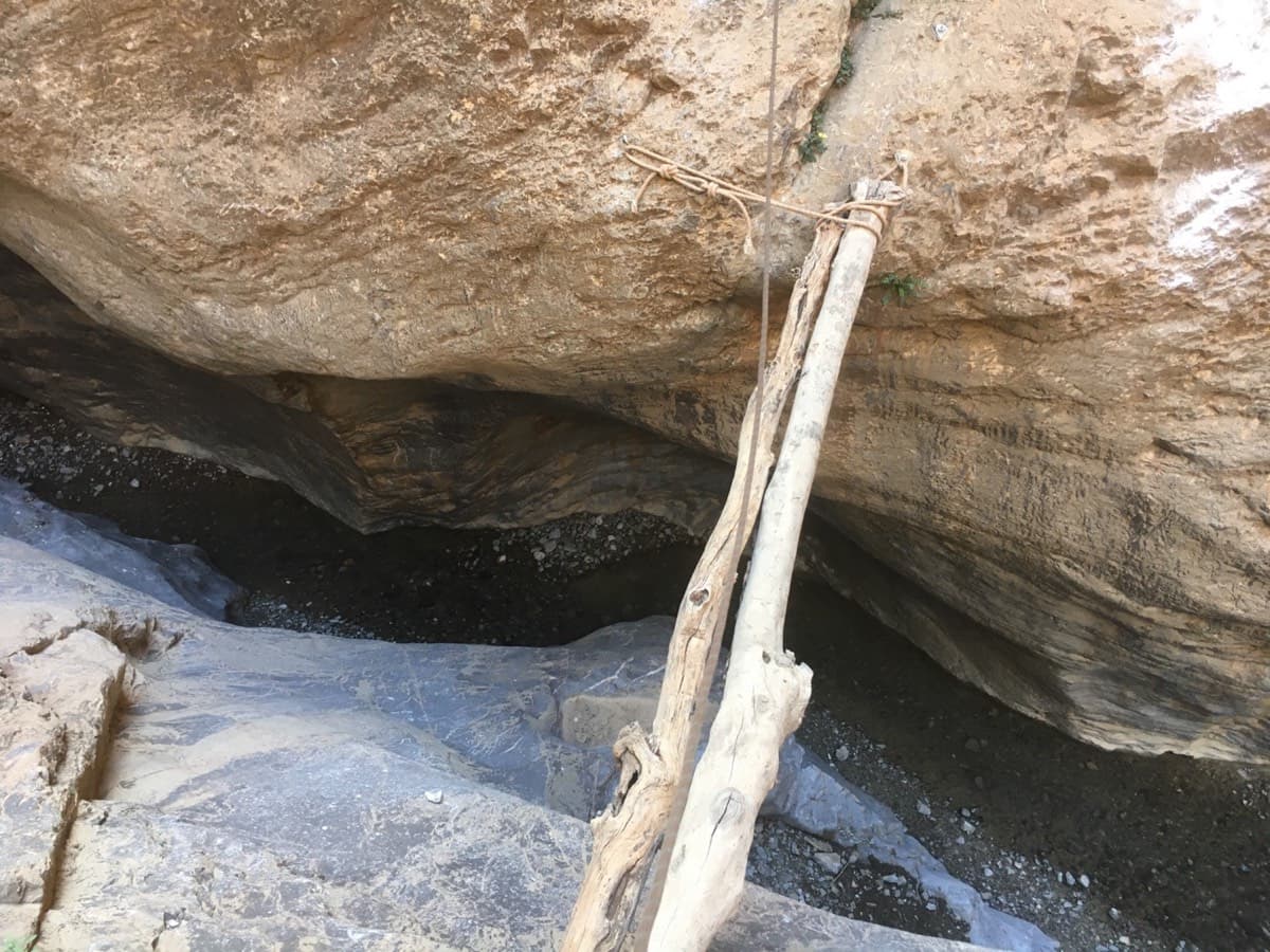 A jammed block in the canyon on the approach, passed with the help of logs lashed in place.