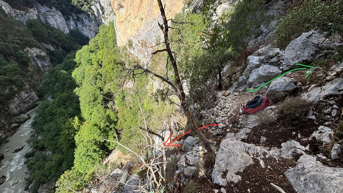 The foot of the route, drawn by a September 2025 party: the green arrow points to the start, the red arrow to the handrail that continues down to the river beach.