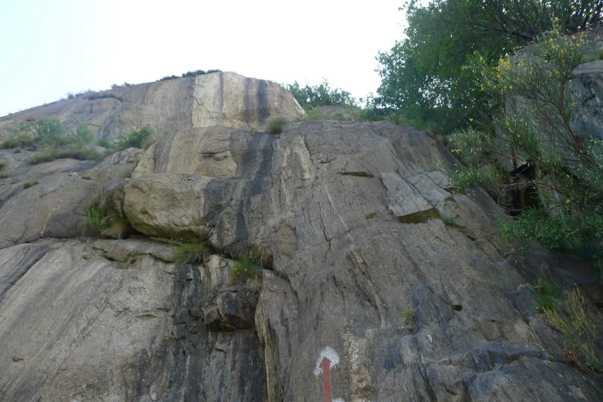 The first pitch of Lo Dzerby seen from the base, with a red arrow painted on the rock at the start (June 2013).