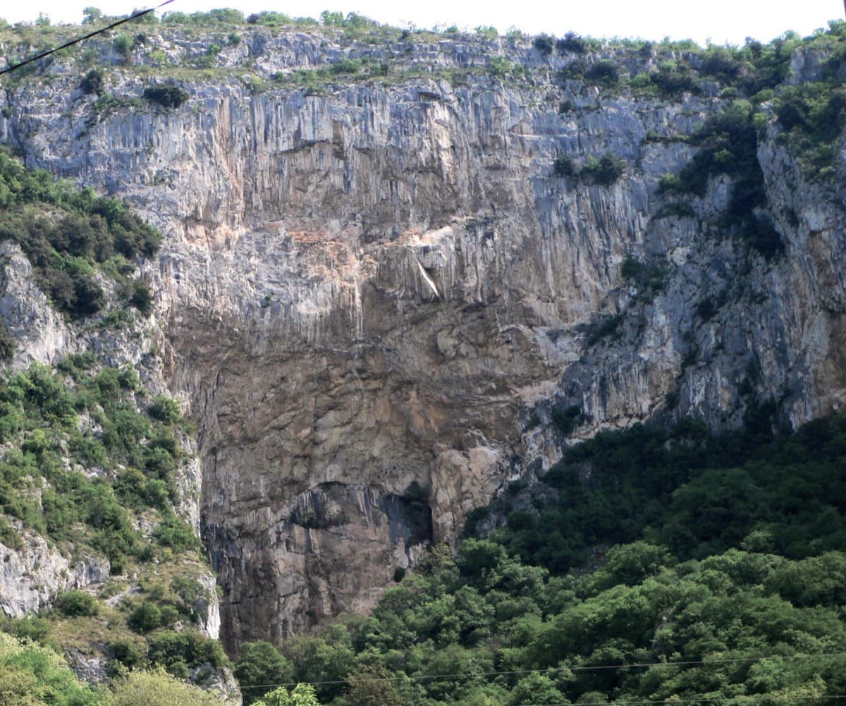 The Velika stena (big wall) above Osp with the large cave at its foot. Medo is on the right-hand side of the wall, reached by the steep path that continues rightwards past the cave.