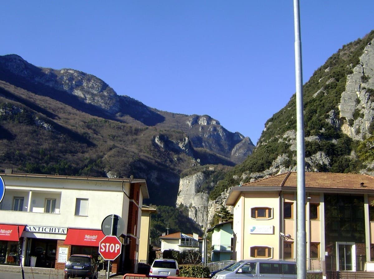 The centre of Sarche (photo geotagged at the main junction), looking towards the rock gateway of the Sarca gorge. The walk-in follows the Comano Terme road towards that gap as far as the bridge.