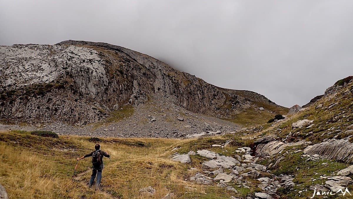 After leaving the GR 11.1: heading across the pasture towards the scree cone below the face. The route starts at the top of the cone.