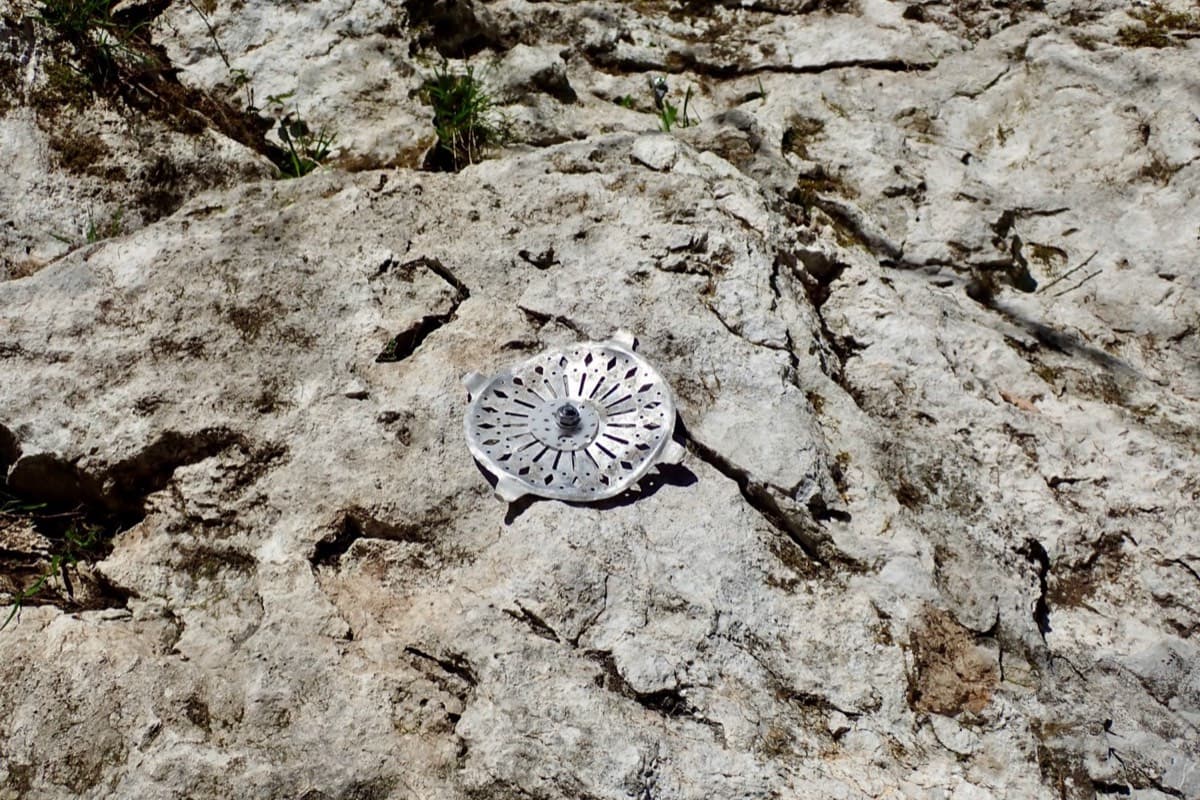 The metal rosette fixed to the rock that marks the start of the route.