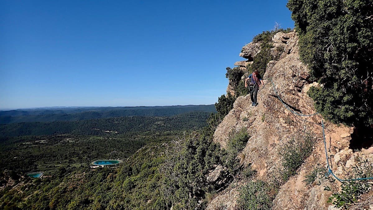The ledge with the fixed rope on the traverse round the foot of the mallo towards the gully; the ponds by the parking are visible below.