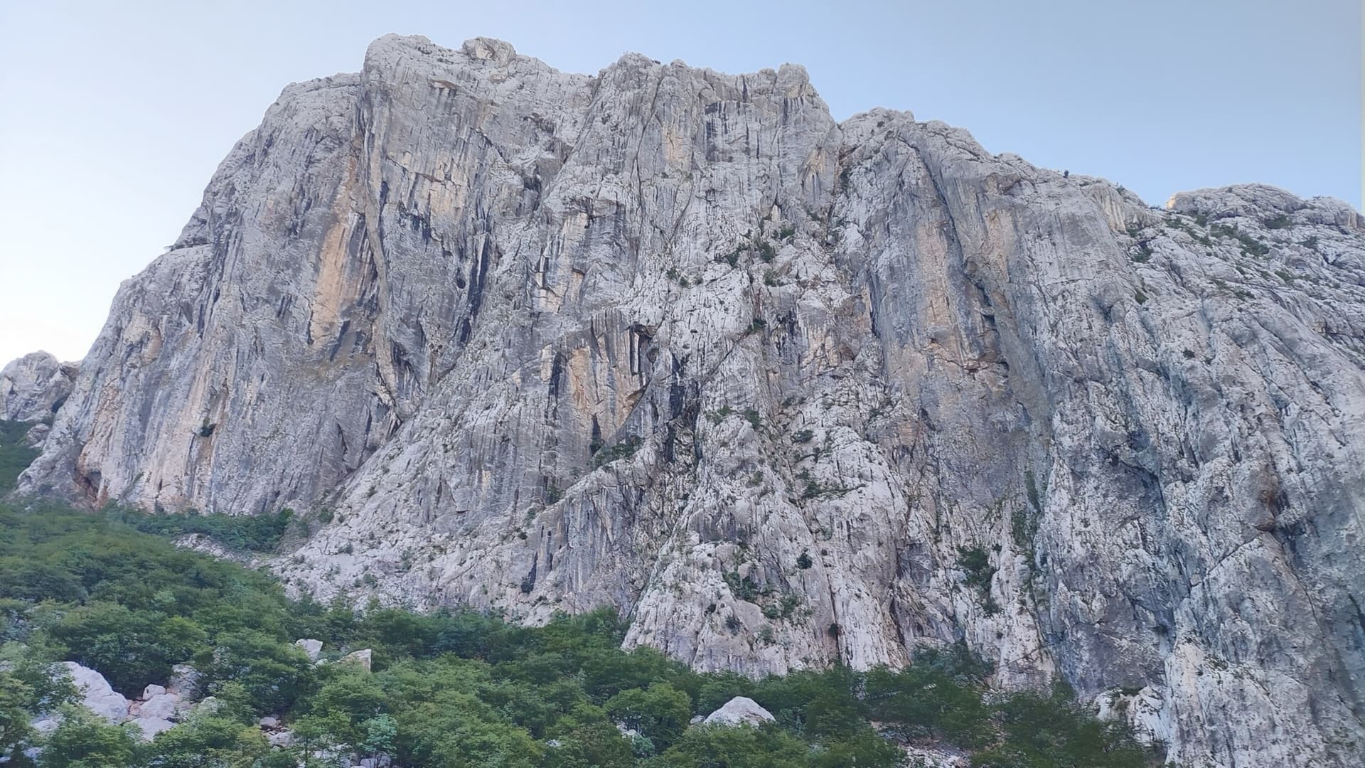 Anića kuk seen from the north-west across the head of the Velika Paklenica canyon, with the north face on its left-hand side; the exact line is not marked.