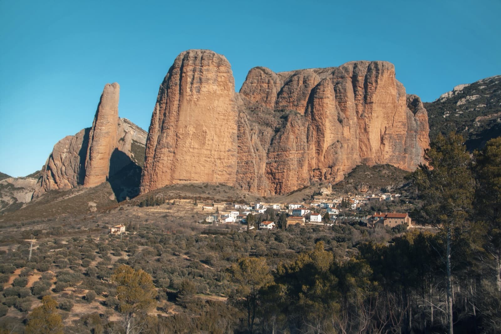Riglos from the south-west: El Puro and Mallo Pisón on the left, the main wall running right to La Visera above the village.