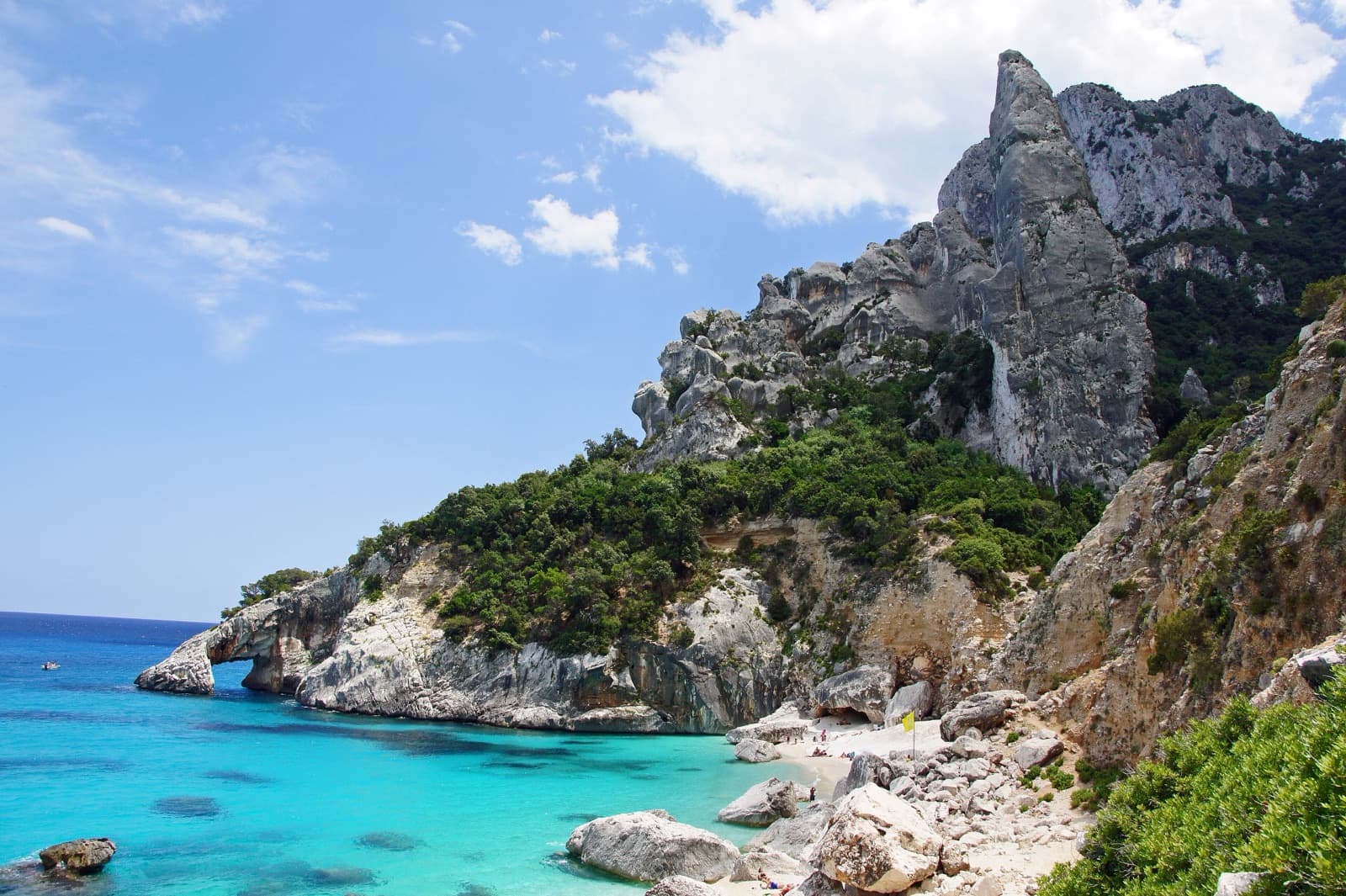 The Aguglia di Goloritzè rising behind the pebble beach of Cala Goloritzè.