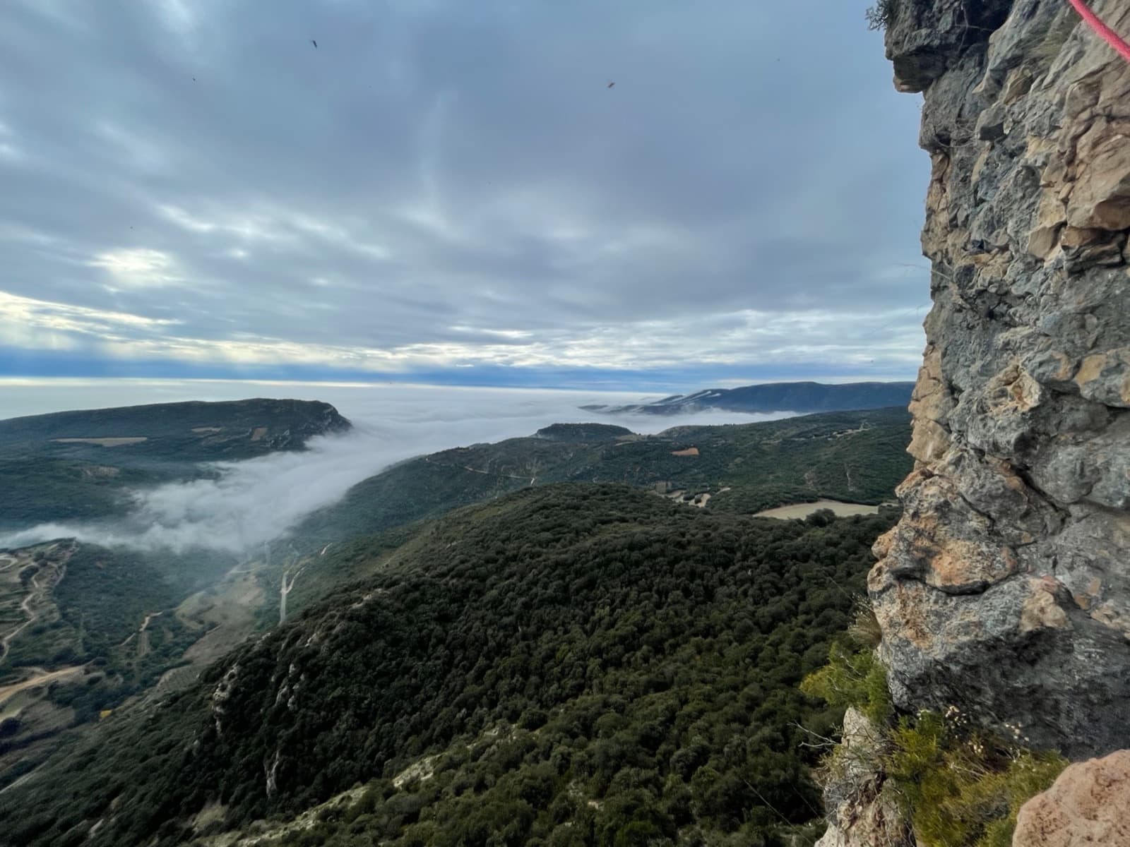 Looking out from the second belay of El Somni de Quimfer over a sea of cloud in the valley.