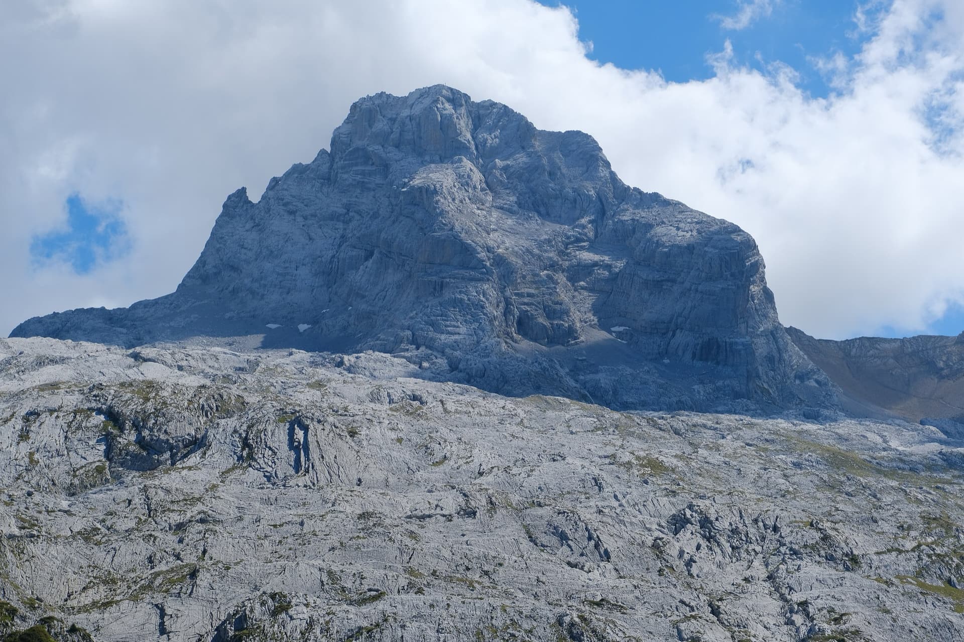 The north-west face of the Pointe Percée rising above the limestone pavement of the Gramusset plateau, seen from the Col des Annes side; Heididoune climbs this face to the summit, the exact line is not marked.