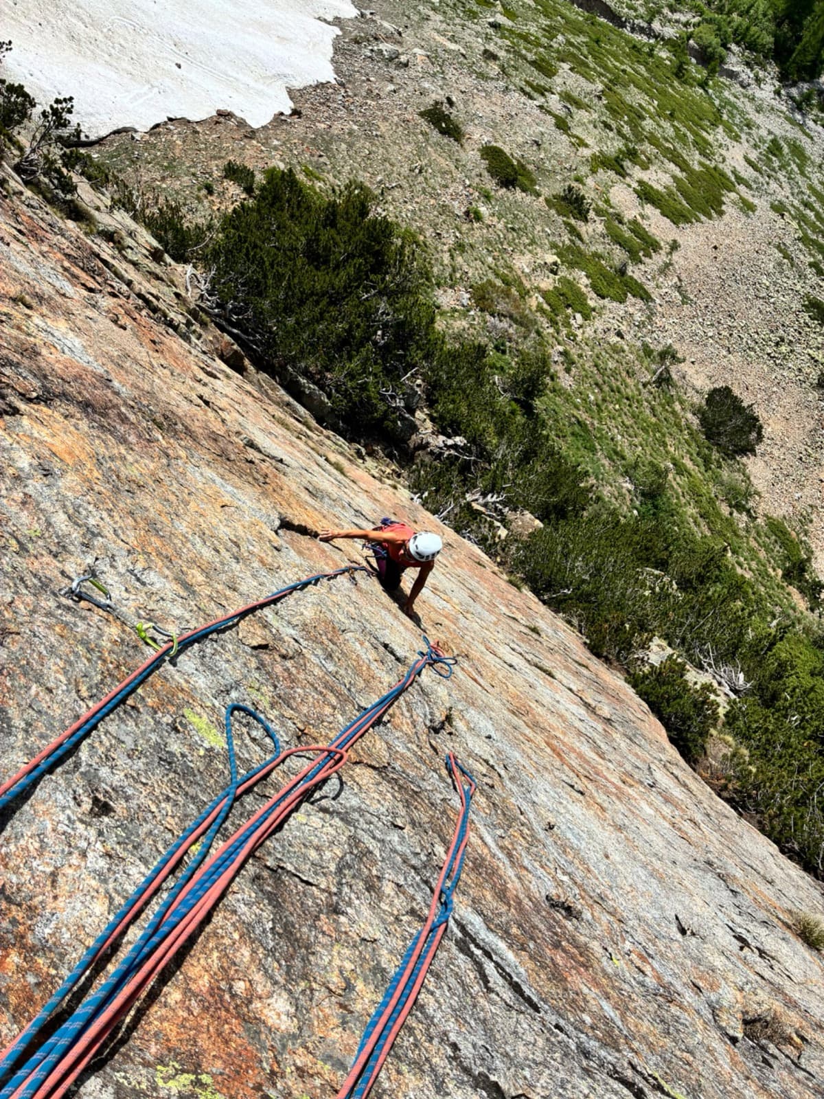 Looking down a compact orange granite slab on Il Gatto e la Volpe to the second climber, Pilier Franco Salluard.