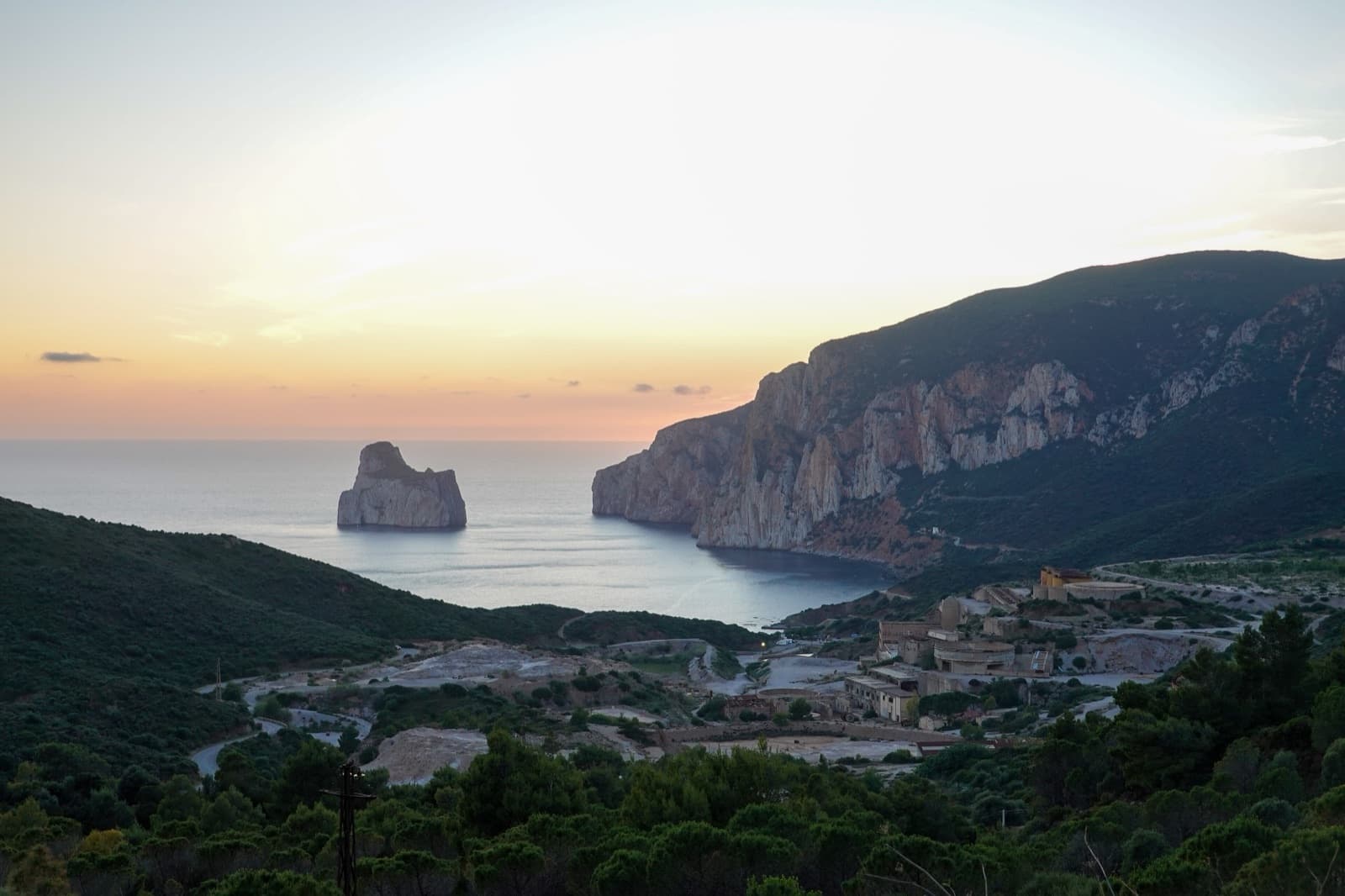 Sunset over Masua: the mine buildings, the cliff of Porto Flavia and the Pan di Zucchero.