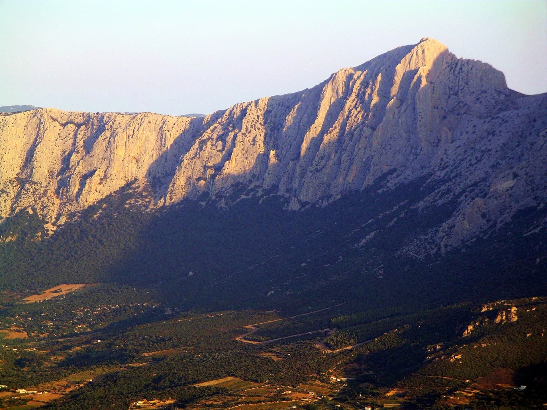 Punta Cusidore (1147 m) and the limestone wall of the Supramonte di Oliena in evening light, seen from the Oliena side.