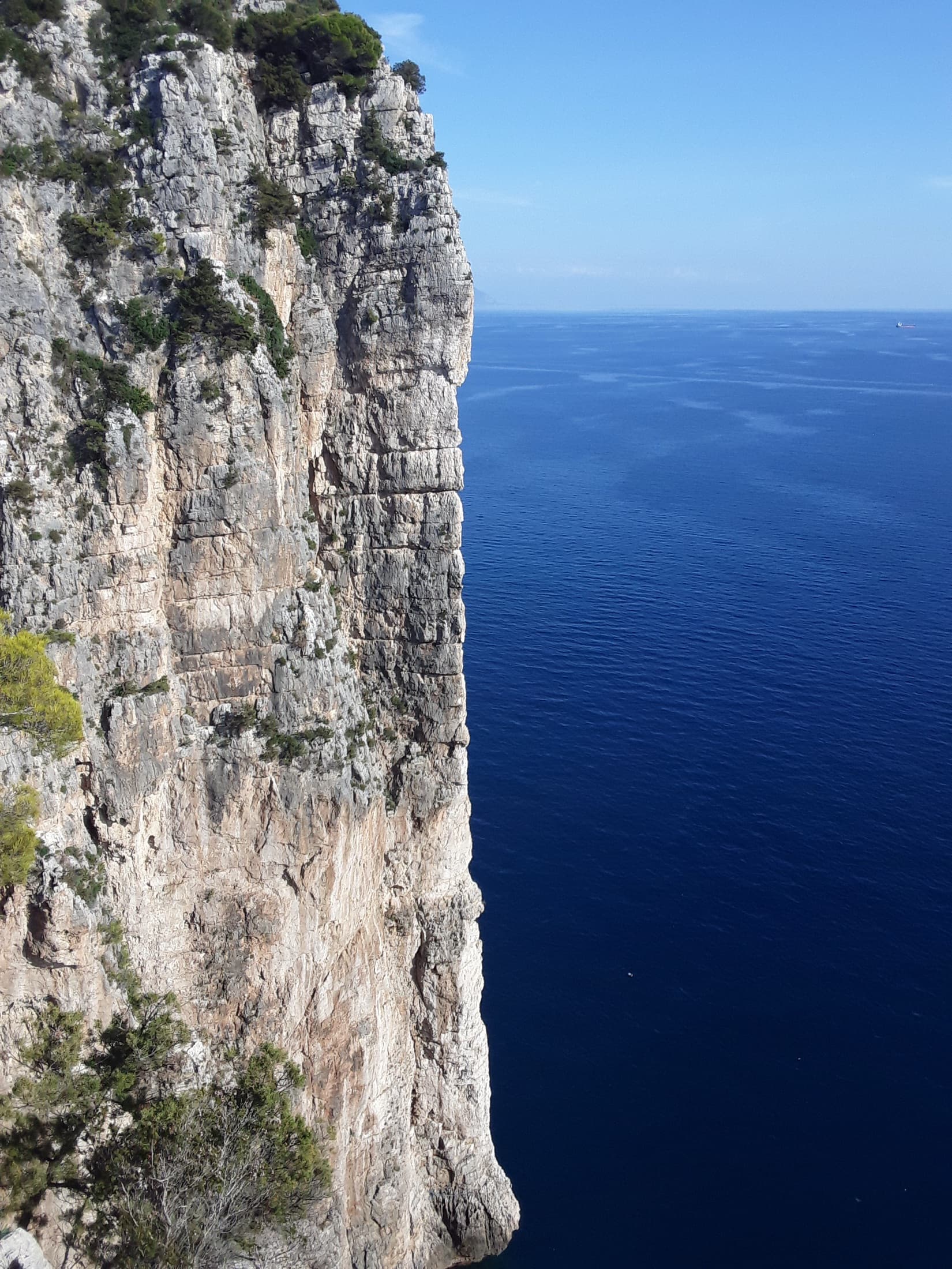 The vertical limestone spur of La Croce del Sud dropping straight into the Tyrrhenian Sea at the Montagna Spaccata, Gaeta.
