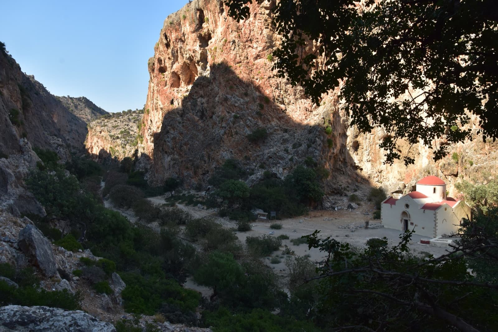 Inside the Agiofarago gorge: the pocketed orange wall above the chapel of Agios Antonios.