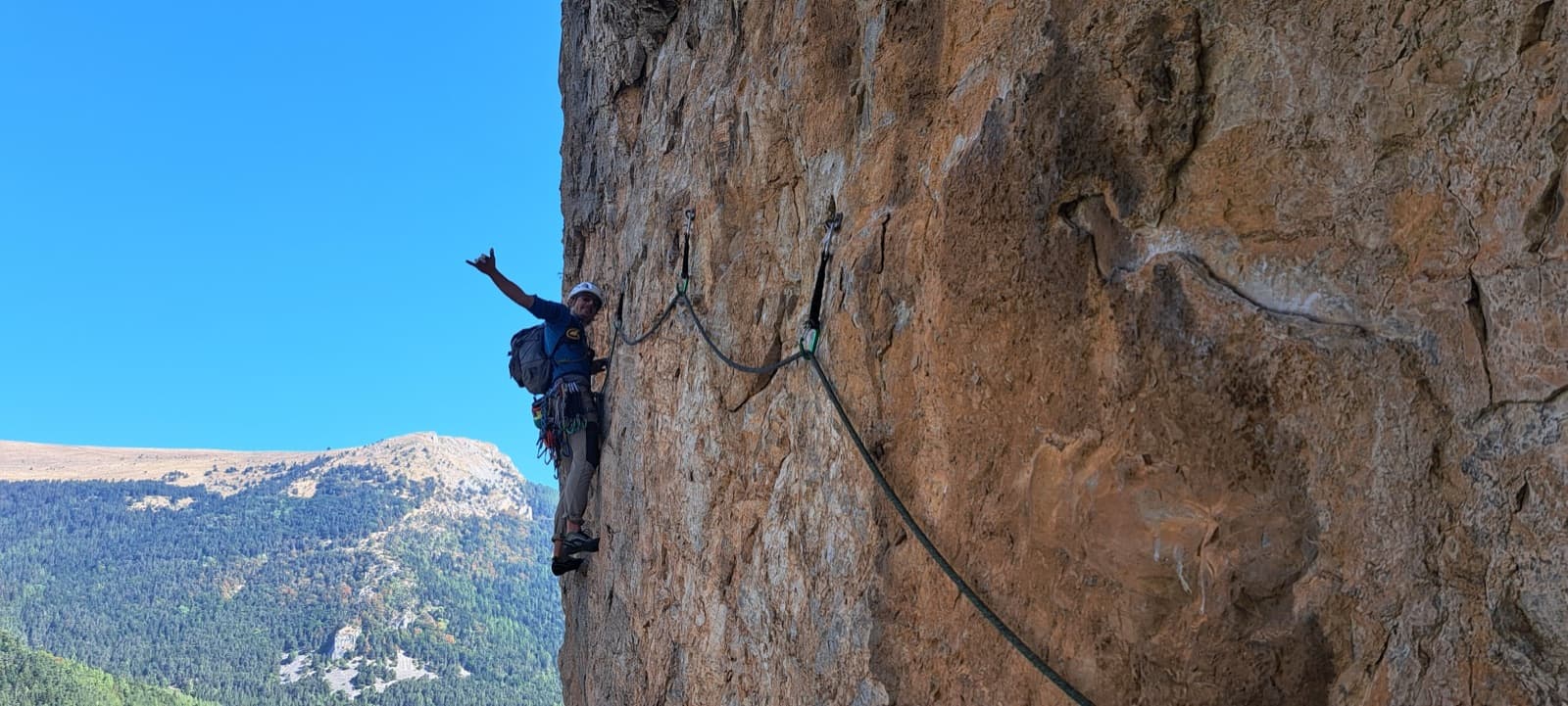 The traverse on pitch 5 (6c) of Les Maîtres du Jeu, on orange limestone high above the Dévoluy forests.