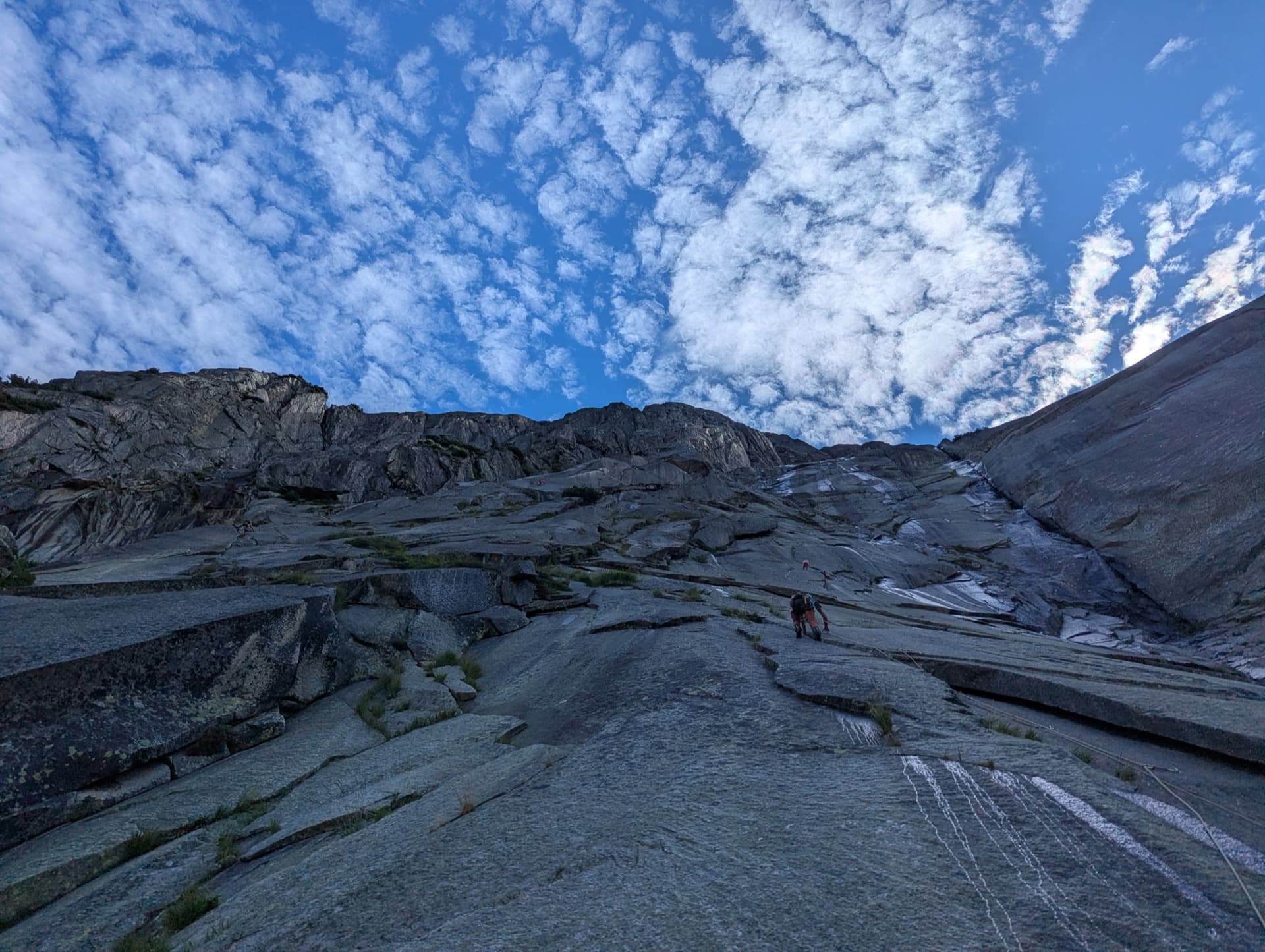The granite slabs of the Gelmerfluh under a mackerel sky, photographed from pitch 3 of Savoir Vivre.
