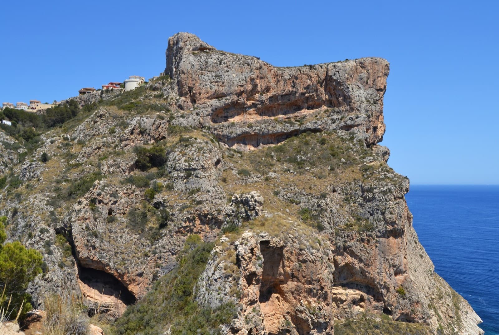 Morro Falquí from the clifftop viewpoints of El Poble Nou de Benitatxell: banded orange limestone dropping straight to the sea.