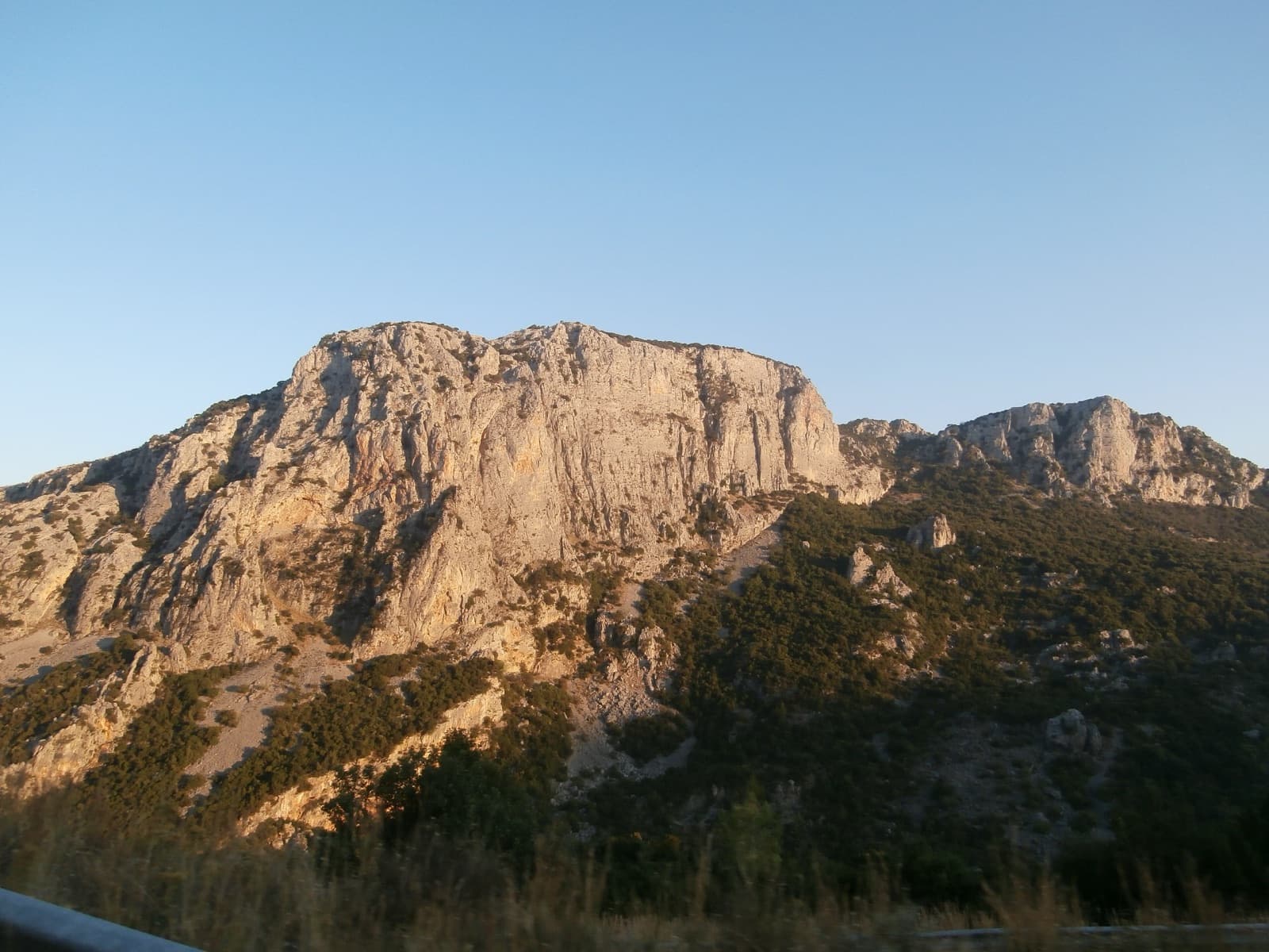 Limestone walls on the south side of the Manikia gorge, Evia, in evening light. This is the gorge the Mpougazi sector lies in; the sector itself is not identified in the photo.
