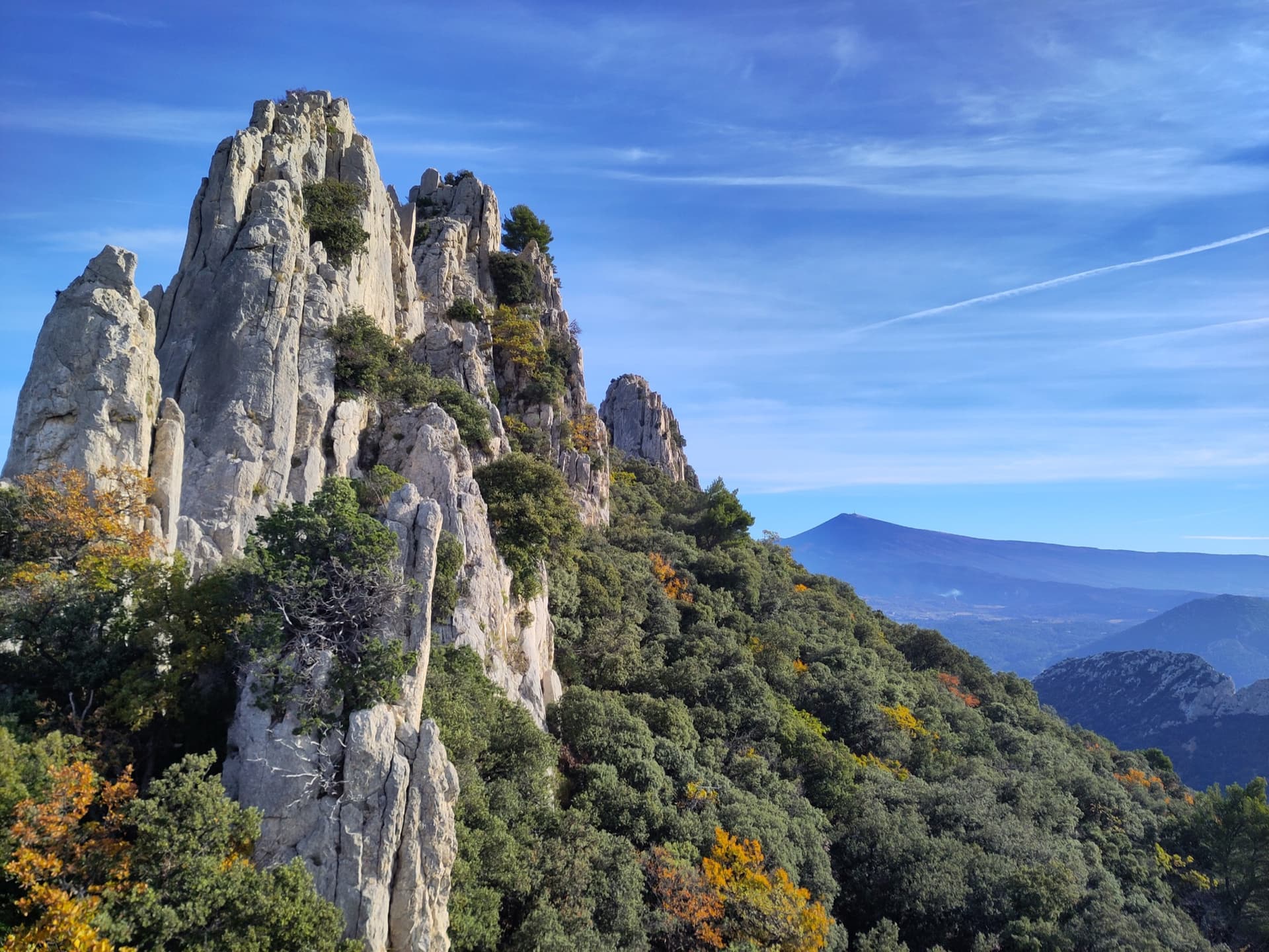 Limestone towers on the Gigondas chain of the Dentelles de Montmirail, photographed during a traverse of the Florets crest, with Mont Ventoux on the horizon.