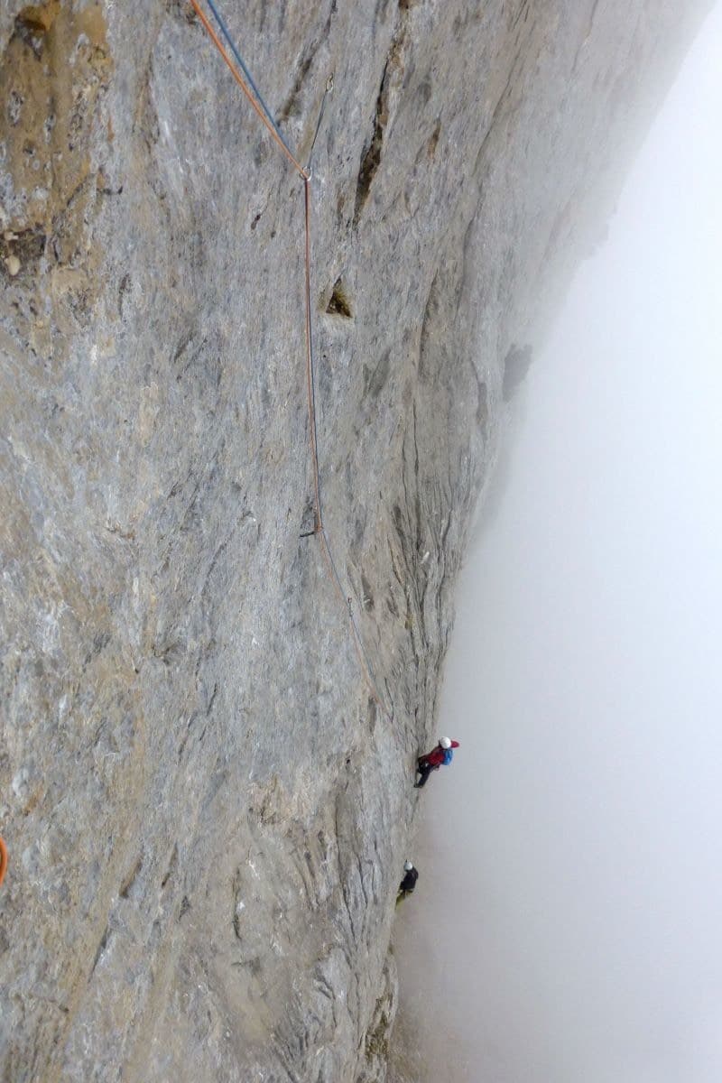 Climbers on the grey limestone of Freedom, Karayalak Towers, as the morning mist clears