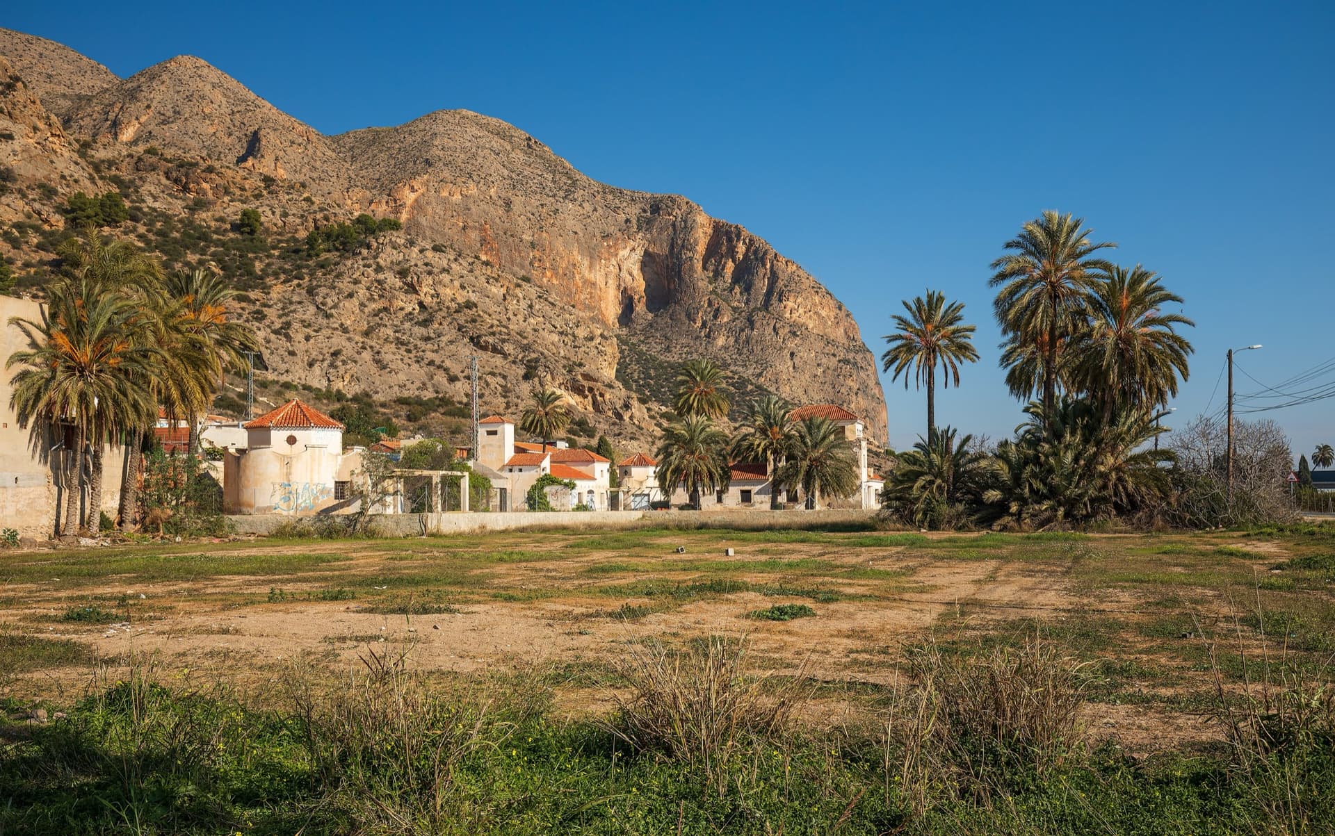 The big orange limestone wall of the Sierra de Callosa directly above Redován, seen from the edge of the village.