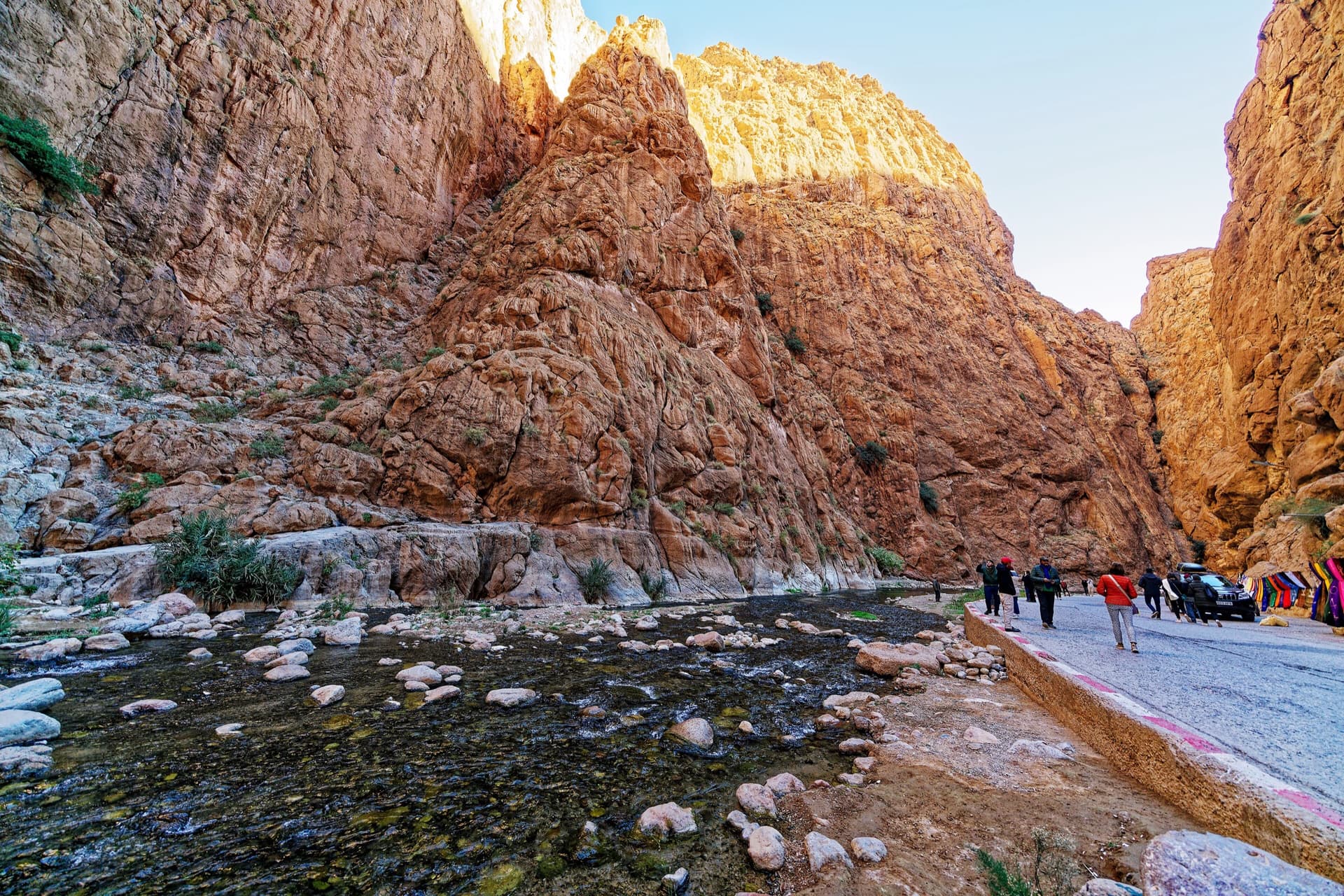 Inside the Todra narrows: the knobbly pointed buttress in the centre is the sector Les pieds dans l'eau, and the tall wall left of the gully beside it, in shade with a sunlit rim, is the Pilier du Couchant, which La Classique climbs.
